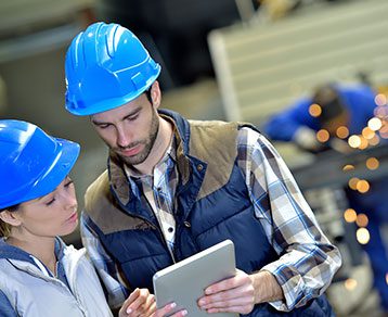 Engineers in steel factory working on digital tablet
